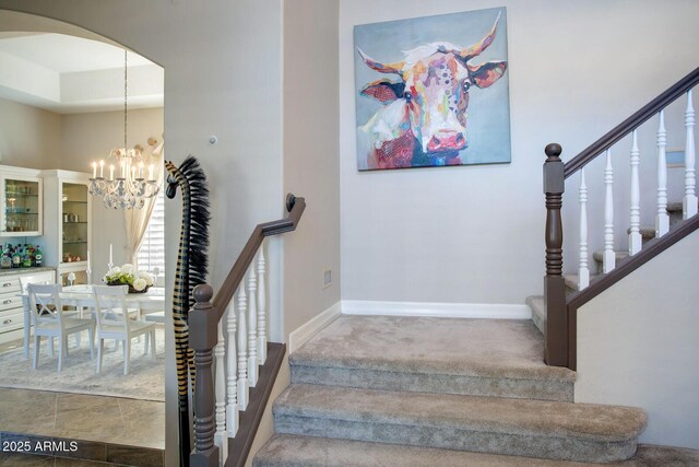 5281 W Quail Ave, Glendale, AZ 85308 - stairs featuring arched walkways, a chandelier, baseboards, and carpet flooring