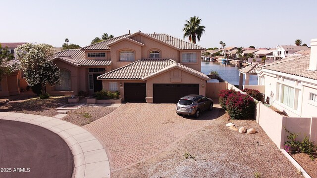 5281 W Quail Ave, Glendale, AZ 85308 - mediterranean / spanish house featuring a water view, a garage, decorative driveway, stucco siding, and fence