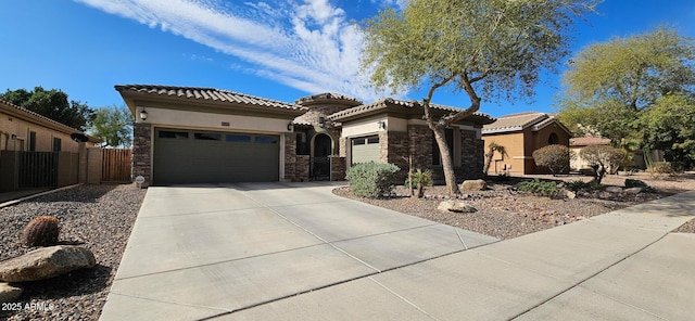 19245 W Pasadena Ave, Litchfield Park, AZ 85340 - mediterranean / spanish house with concrete driveway, an attached garage, stucco siding, stone siding, and fence