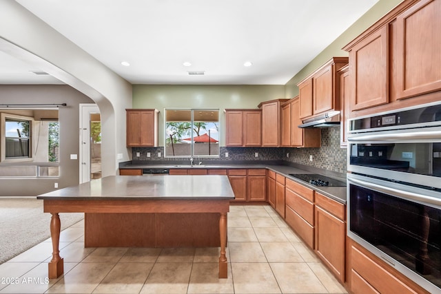 19245 W Pasadena Ave, Litchfield Park, AZ 85340 - kitchen with stainless steel double oven, black electric stovetop, under cabinet range hood, a sink, and tasteful backsplash