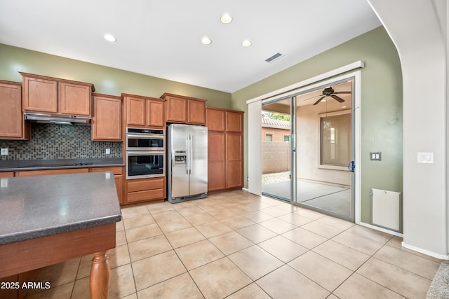 19245 W Pasadena Ave, Litchfield Park, AZ 85340 - kitchen featuring appliances with stainless steel finishes, brown cabinets, tasteful backsplash, ceiling fan, and recessed lighting