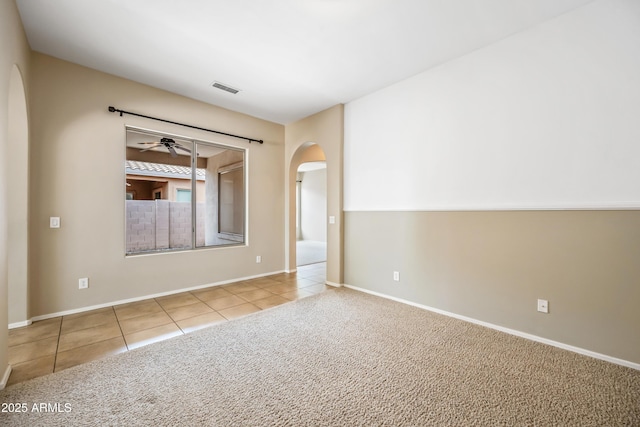 19245 W Pasadena Ave, Litchfield Park, AZ 85340 - tiled empty room with arched walkways, a ceiling fan, baseboards, and carpet floors