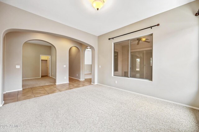 19245 W Pasadena Ave, Litchfield Park, AZ 85340 - tiled spare room featuring carpet, arched walkways, and baseboards
