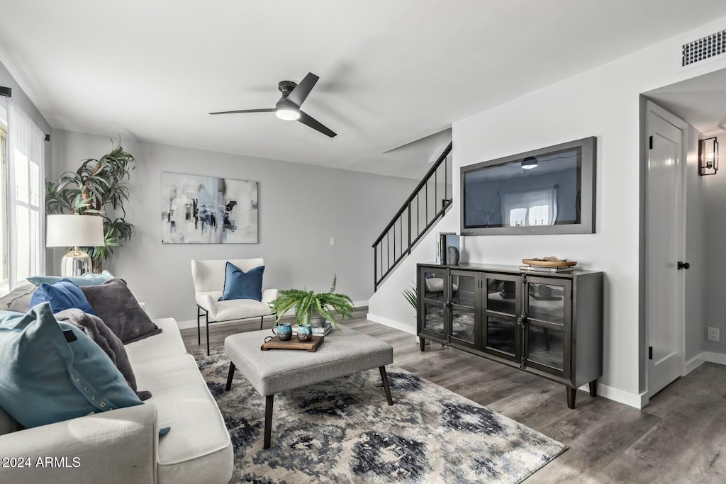 living room with ceiling fan and dark hardwood / wood-style flooring