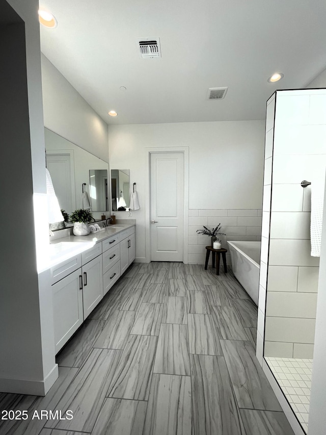 bathroom featuring vanity and separate shower and tub