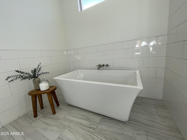 bathroom with a bathtub and tile walls