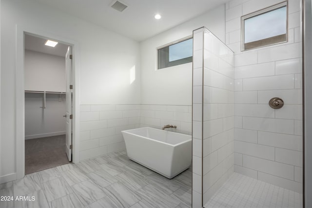 bathroom with plus walk in shower and tile walls