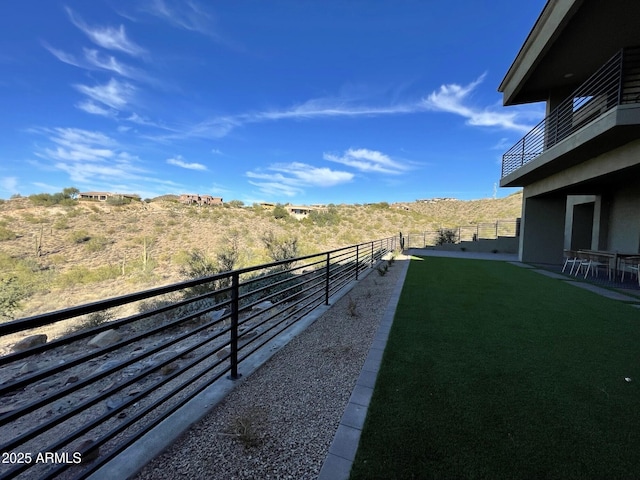 view of yard with a balcony