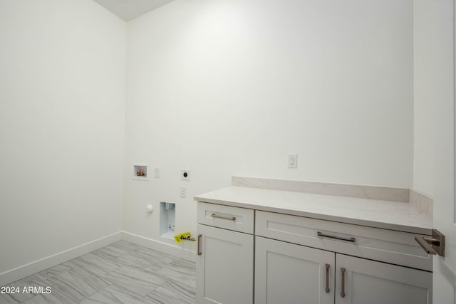 laundry area featuring hookup for an electric dryer, washer hookup, hookup for a gas dryer, and cabinets