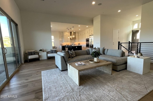 living room with light hardwood / wood-style floors, an inviting chandelier, and a wealth of natural light