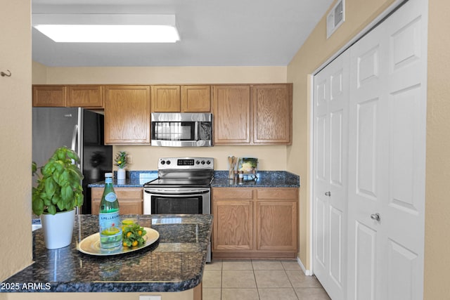 kitchen featuring light tile patterned flooring and appliances with stainless steel finishes