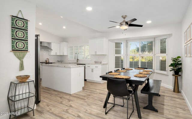 13620 N 80th Pl, Scottsdale, AZ 85260 - kitchen with wall chimney exhaust hood, backsplash, a ceiling fan, white cabinets, and light wood finished floors