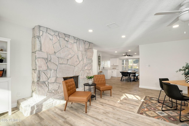13620 N 80th Pl, Scottsdale, AZ 85260 - living area featuring ceiling fan, light wood-style flooring, a stone fireplace, recessed lighting, and baseboards