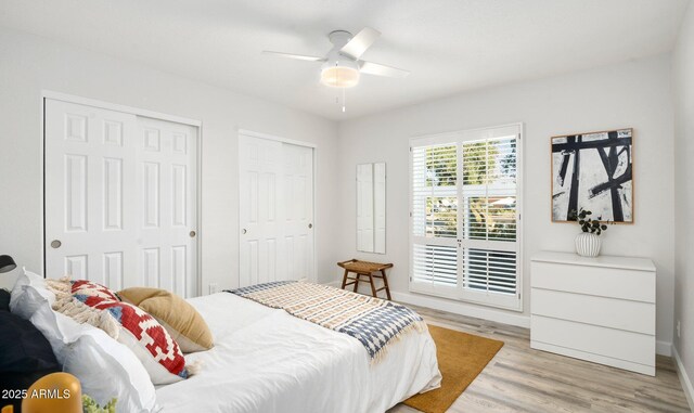 13620 N 80th Pl, Scottsdale, AZ 85260 - bedroom with two closets, light wood-style floors, ceiling fan, and baseboards