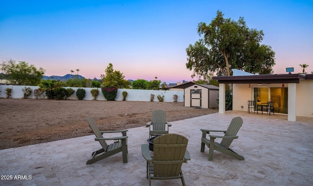 13620 N 80th Pl, Scottsdale, AZ 85260 - patio terrace at dusk featuring a patio, a fire pit, a fenced backyard, and outdoor dining area