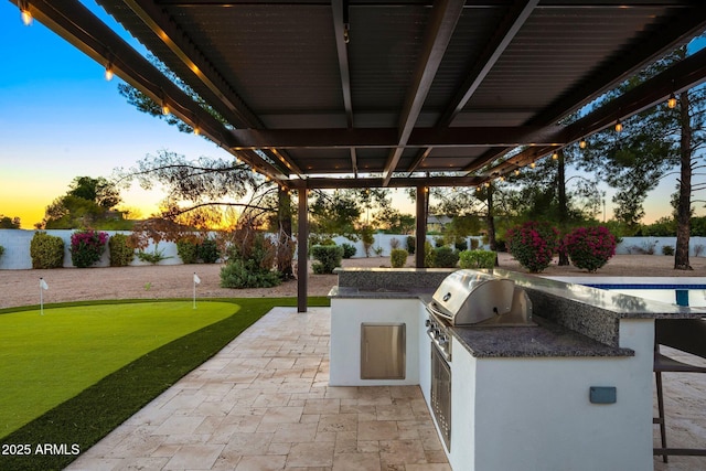 13620 N 80th Pl, Scottsdale, AZ 85260 - patio terrace at dusk featuring a patio, a putting green, a fenced backyard, and a bar