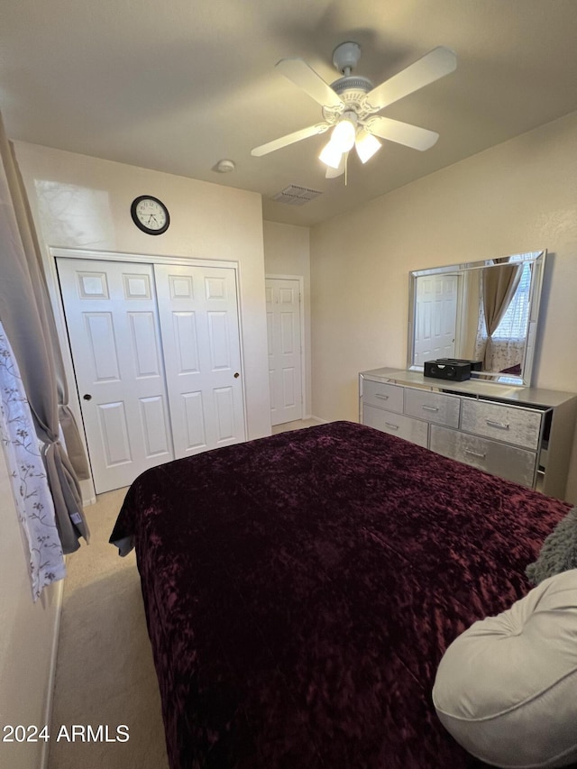 carpeted bedroom with ceiling fan and a closet