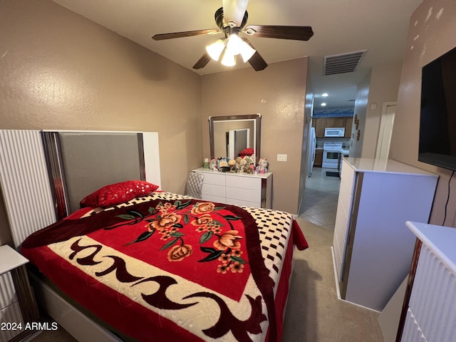 carpeted bedroom featuring ceiling fan and stainless steel refrigerator