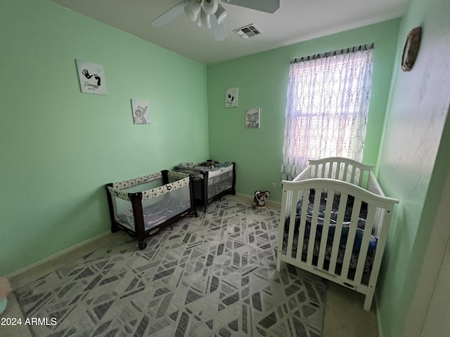 bedroom with ceiling fan and a crib