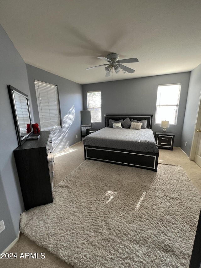 bedroom featuring light carpet and multiple windows