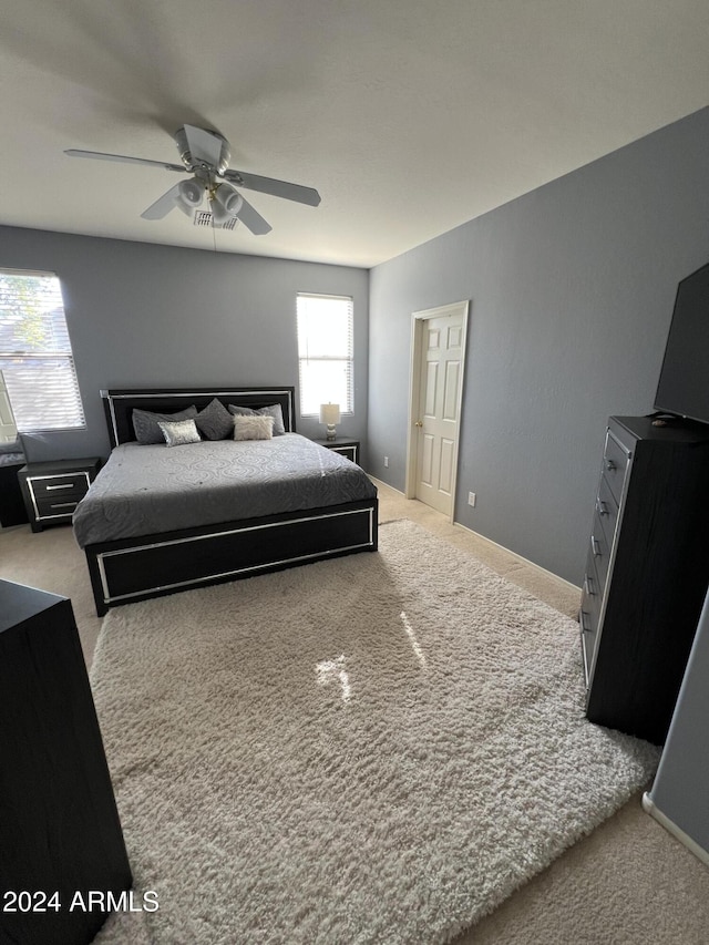 bedroom featuring light carpet and ceiling fan