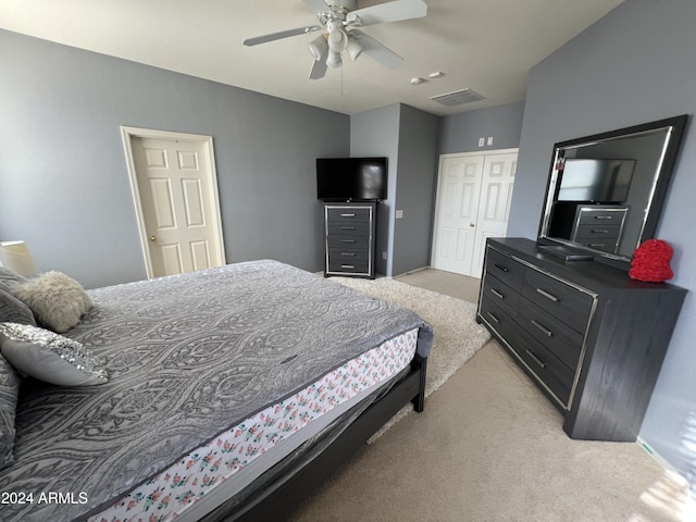 bedroom with a closet, light colored carpet, and ceiling fan