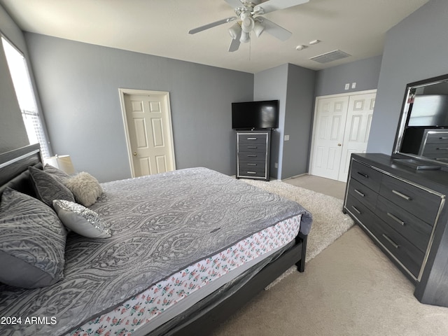 carpeted bedroom featuring ceiling fan and a closet