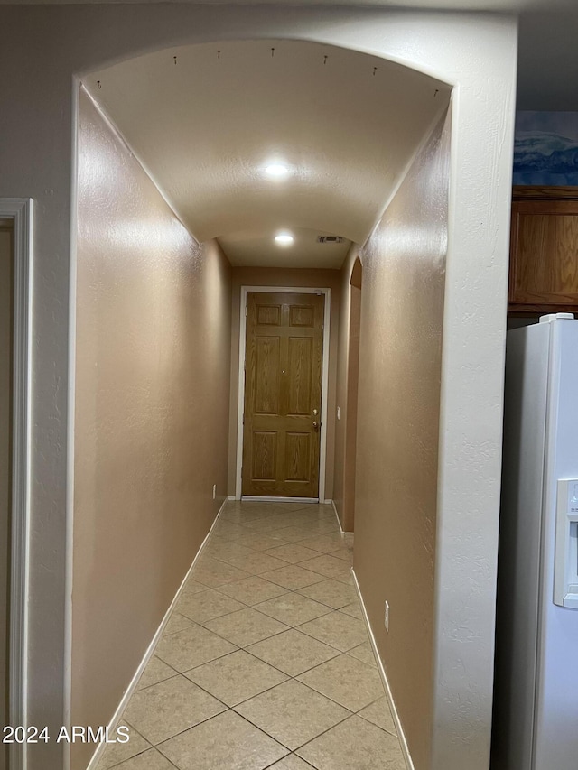 hall with light tile patterned floors