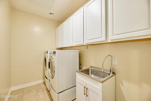 laundry room featuring sink, light tile patterned flooring, separate washer and dryer, and cabinets