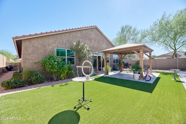 rear view of property with a yard, a gazebo, and a patio