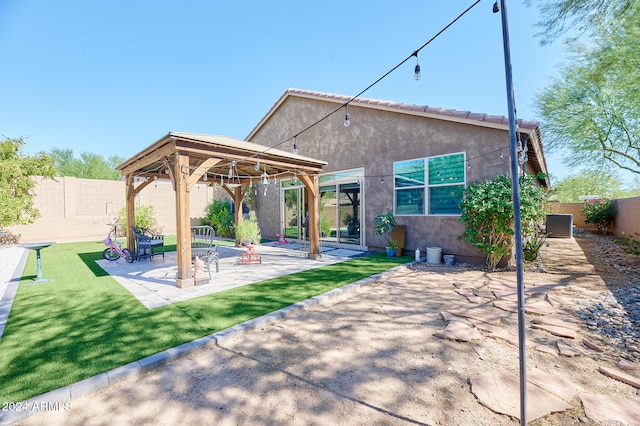 rear view of property featuring a patio, a gazebo, and a lawn