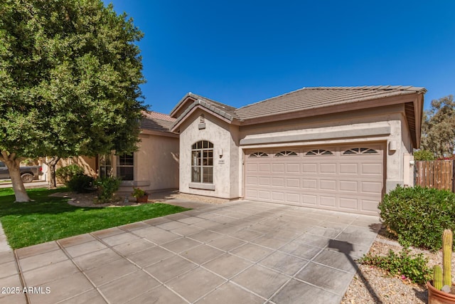 view of front of house featuring a garage, driveway, a tile roof, and stucco siding