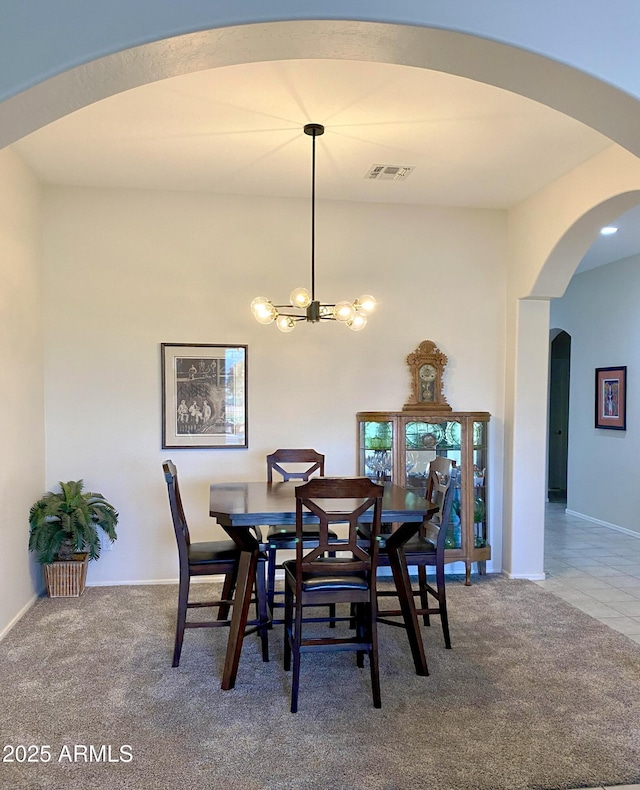 dining area with arched walkways, visible vents, an inviting chandelier, carpet flooring, and baseboards