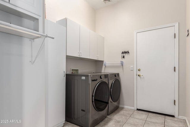 laundry area with light tile patterned flooring, visible vents, baseboards, cabinet space, and washing machine and clothes dryer