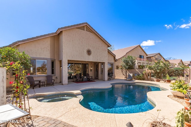 view of swimming pool featuring a pool with connected hot tub, a patio area, and fence