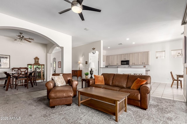 living area with light tile patterned floors, ceiling fan, arched walkways, and recessed lighting