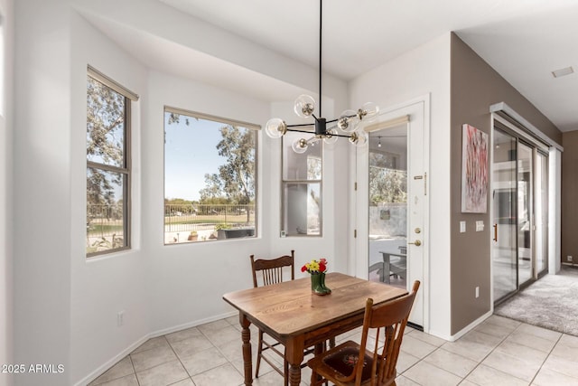 dining room with an inviting chandelier, baseboards, and light tile patterned flooring