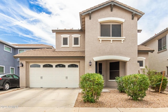 view of front of property featuring concrete driveway, a tiled roof, and stucco siding