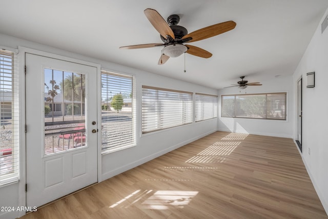 unfurnished sunroom with a wealth of natural light, lofted ceiling, and ceiling fan