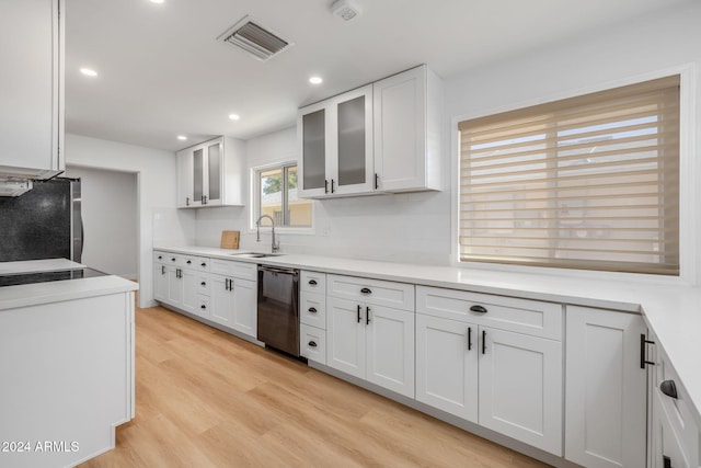 kitchen featuring sink, light hardwood / wood-style flooring, white cabinets, stainless steel fridge, and dishwasher