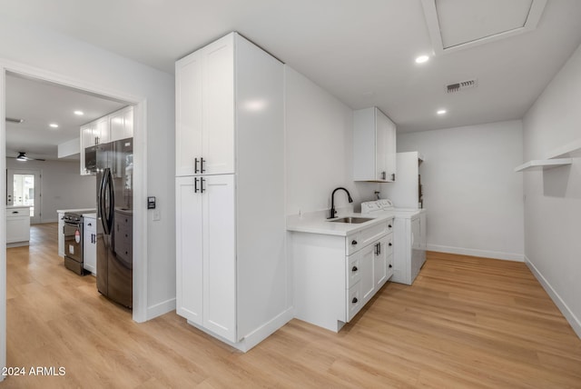 kitchen featuring black range with electric cooktop, stainless steel fridge, white cabinetry, sink, and light hardwood / wood-style flooring