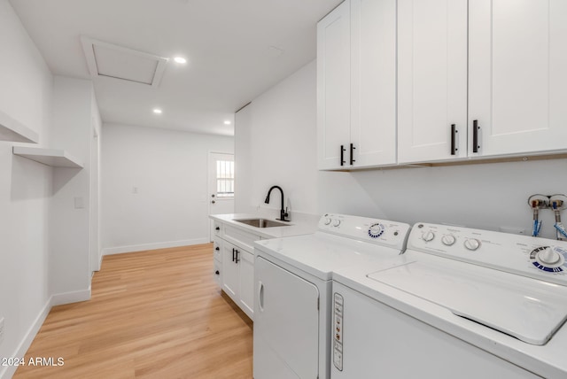 laundry room featuring cabinets, separate washer and dryer, light hardwood / wood-style flooring, and sink