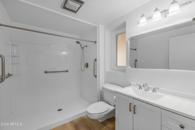 bathroom with a shower, wood-type flooring, vanity, and toilet