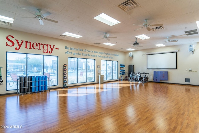 workout room with light hardwood / wood-style flooring and a drop ceiling