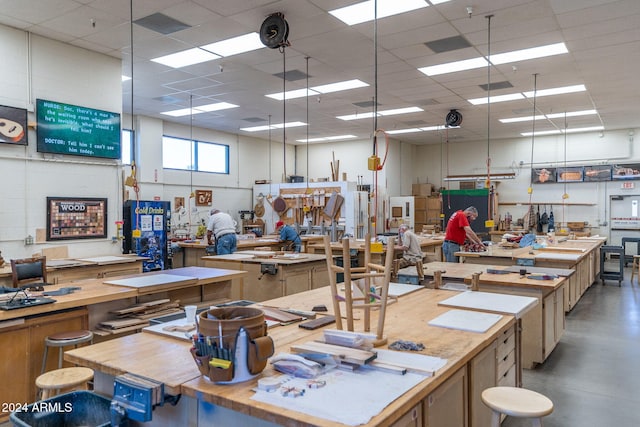 miscellaneous room featuring a drop ceiling and a workshop area