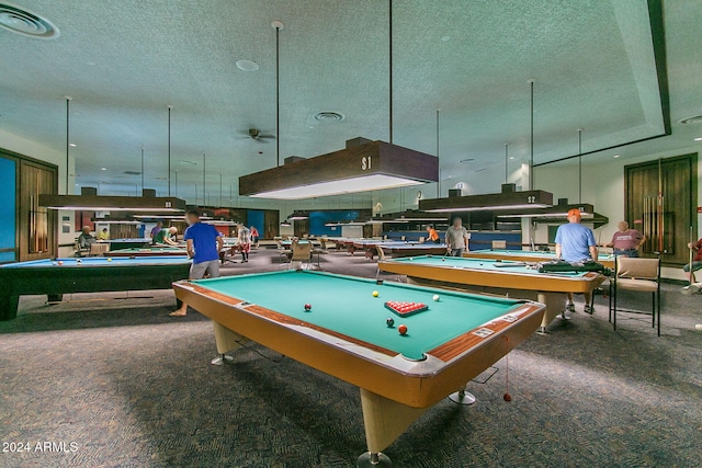 recreation room with pool table, dark colored carpet, and a textured ceiling