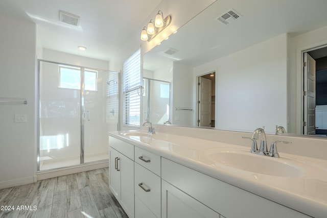 bathroom with vanity, hardwood / wood-style flooring, and a shower with door