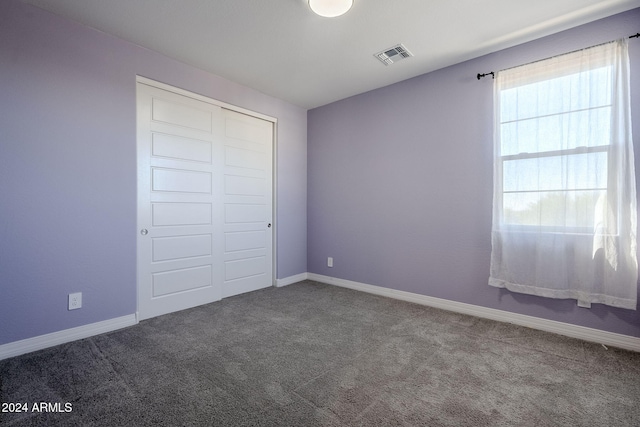 unfurnished bedroom featuring carpet flooring and a closet