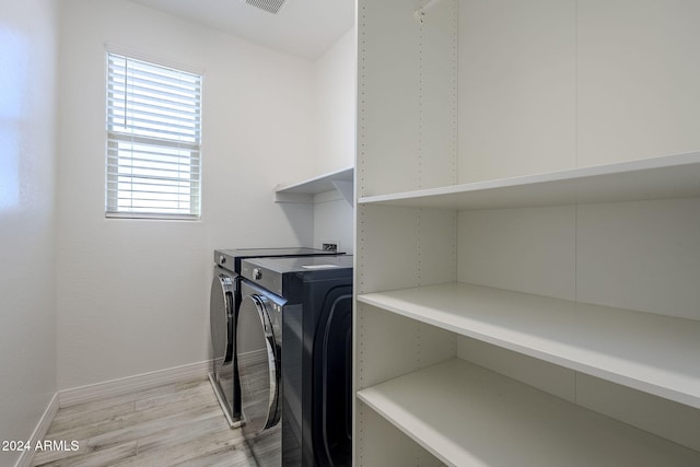 laundry room featuring washer and dryer and light hardwood / wood-style floors