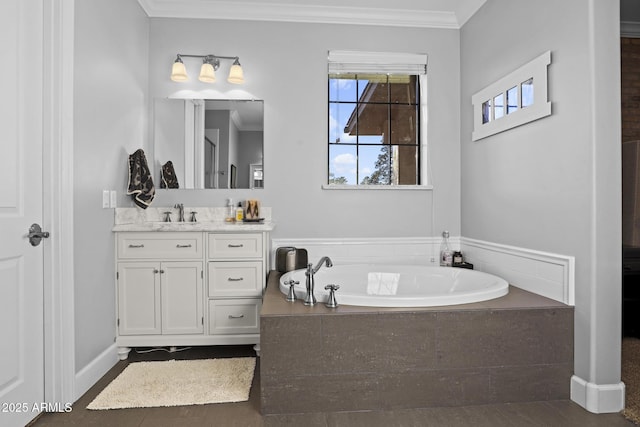 bathroom with baseboards, a garden tub, vanity, and crown molding